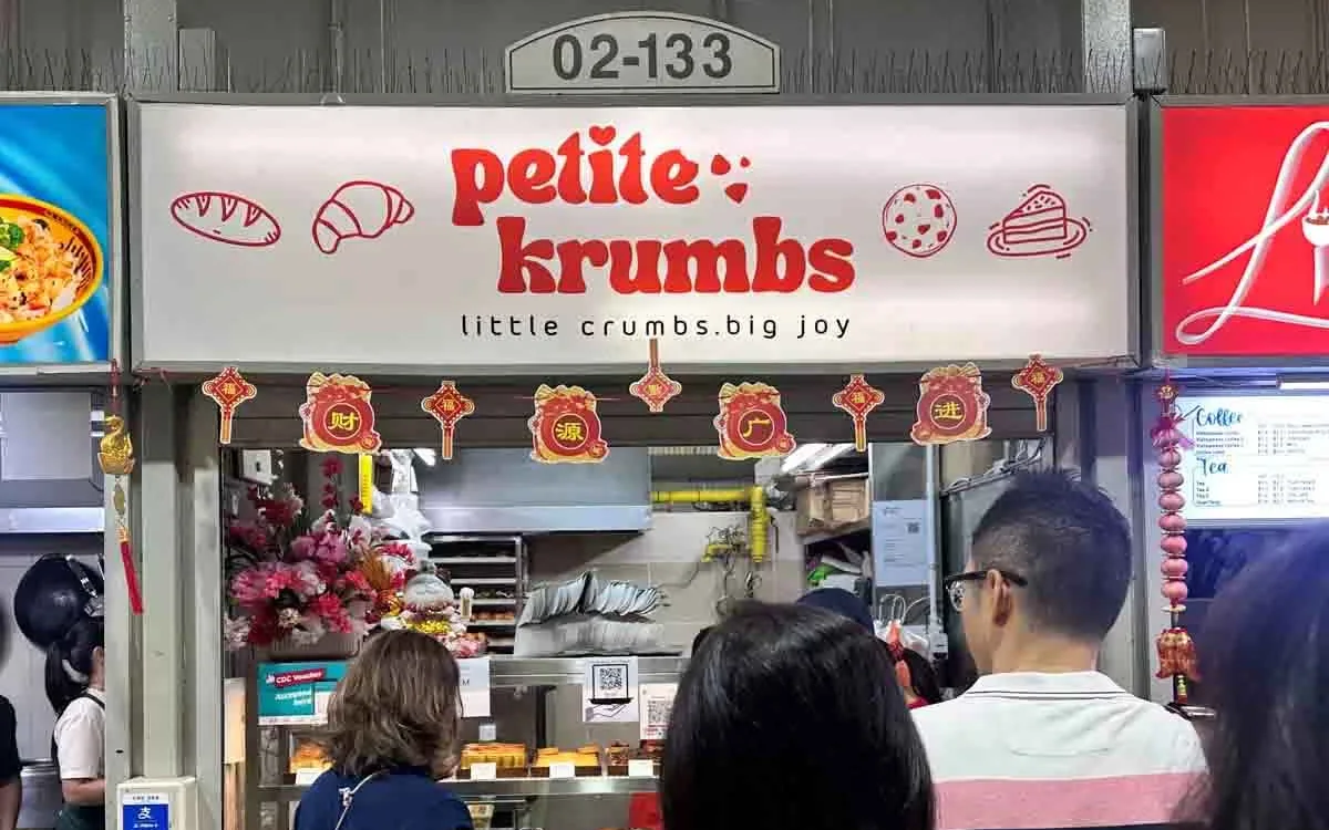 The Petite Krumbs signboard at #02-133 with customers queuing at the counter